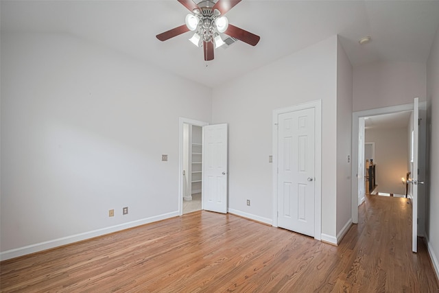 unfurnished bedroom with light wood-style floors, baseboards, visible vents, a ceiling fan, and lofted ceiling