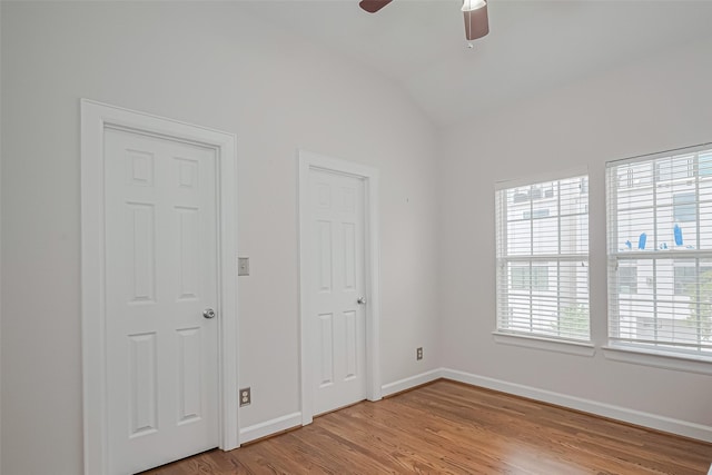 unfurnished bedroom featuring a ceiling fan, baseboards, lofted ceiling, and light wood-type flooring