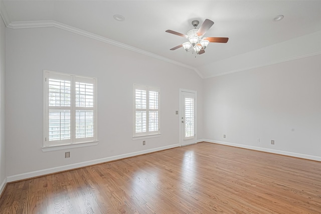 empty room featuring light wood-style flooring, ornamental molding, and lofted ceiling