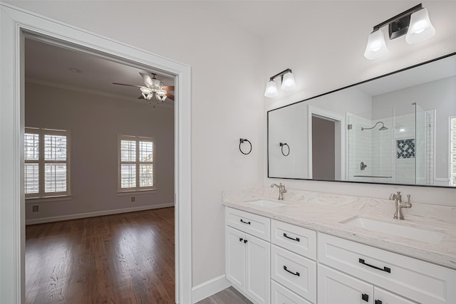 full bath with wood finished floors, a shower stall, crown molding, and a sink