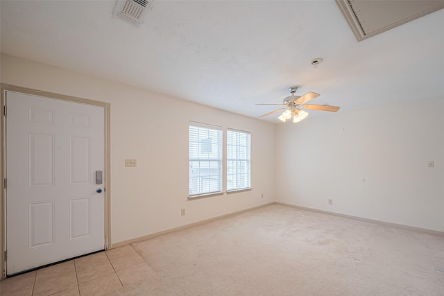 unfurnished room with attic access, a ceiling fan, visible vents, light carpet, and baseboards