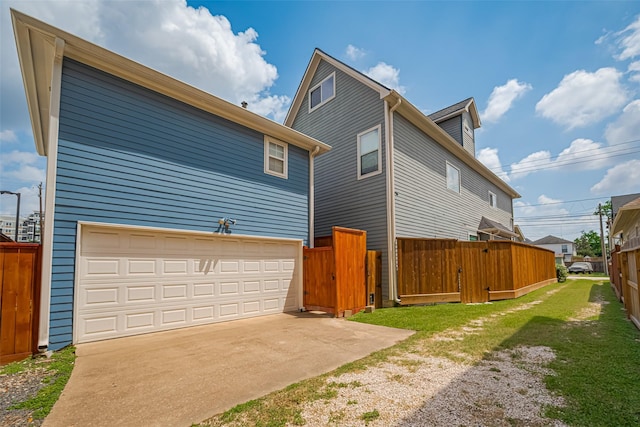 view of side of home featuring fence, concrete driveway, and an attached garage