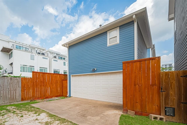 view of side of property featuring fence and an attached garage