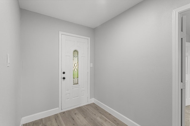 foyer with baseboards and light wood-style flooring