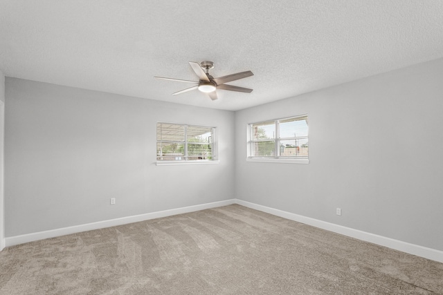 unfurnished room featuring carpet floors, a ceiling fan, a textured ceiling, and baseboards