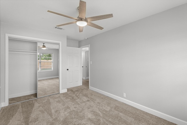 unfurnished bedroom with ceiling fan, visible vents, carpet floors, baseboards, and a closet