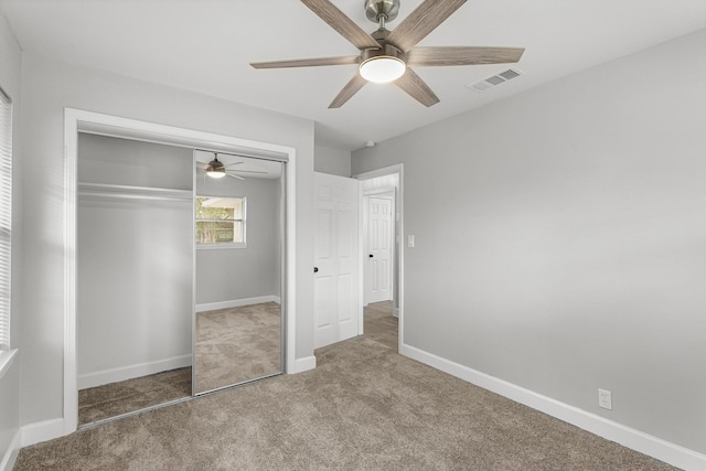 unfurnished bedroom featuring visible vents, carpet floors, a closet, baseboards, and ceiling fan