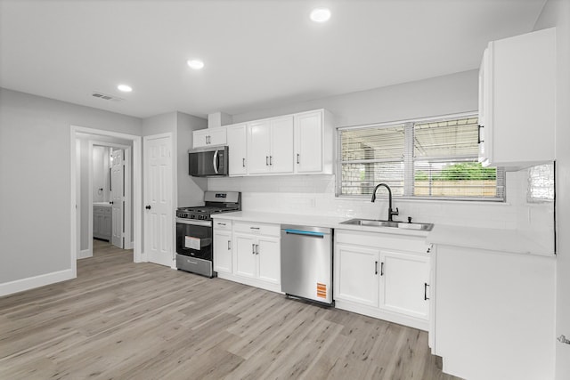kitchen featuring light wood-style flooring, appliances with stainless steel finishes, a sink, and visible vents