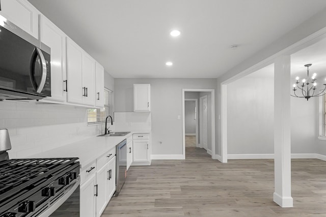 kitchen with a sink, stainless steel appliances, baseboards, recessed lighting, and decorative backsplash