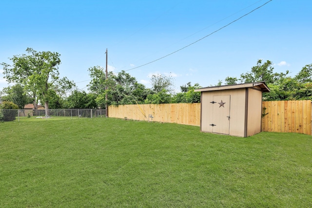 view of yard featuring a storage shed, an outbuilding, and a fenced backyard
