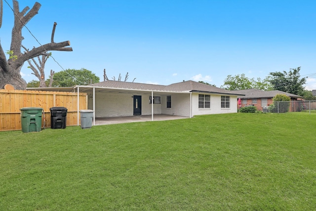 back of property with a lawn, fence, and a patio
