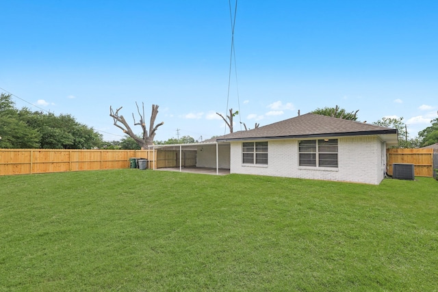 back of house featuring central AC, brick siding, a fenced backyard, a patio, and a yard