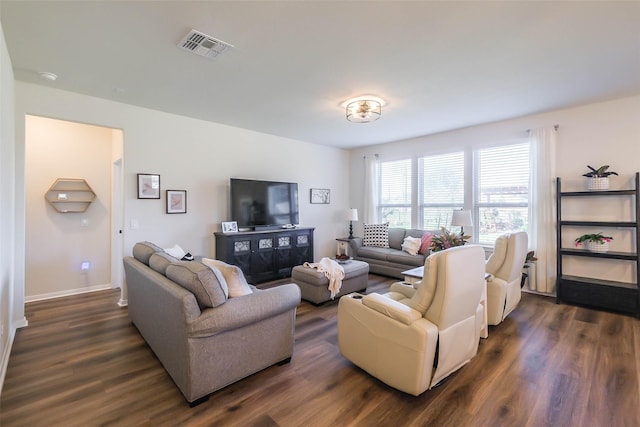 living room with dark wood finished floors, visible vents, and baseboards