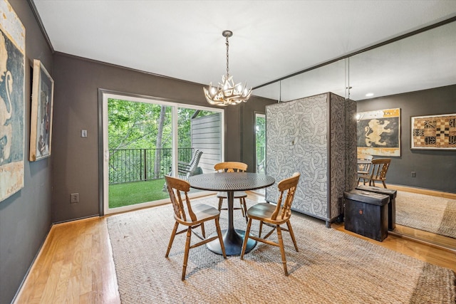 dining space featuring an inviting chandelier, baseboards, and wood finished floors