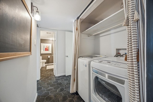 laundry room with independent washer and dryer, baseboards, visible vents, dark tile patterned floors, and laundry area