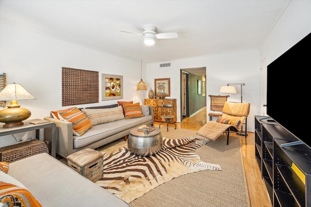 living room with light wood finished floors, a ceiling fan, and visible vents