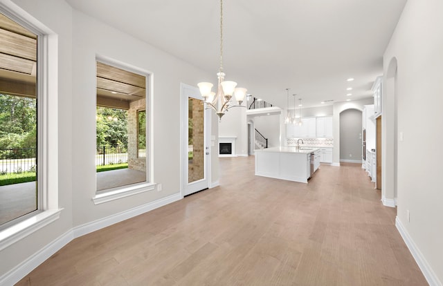 10719 Jacobina Ct, Cypress, TX 77433 - unfurnished dining area with recessed lighting, arched walkways, a notable chandelier, and light wood-style floors