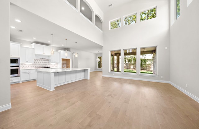 10719 Jacobina Ct, Cypress, TX 77433 - unfurnished living room with baseboards, light wood-style flooring, and a sink
