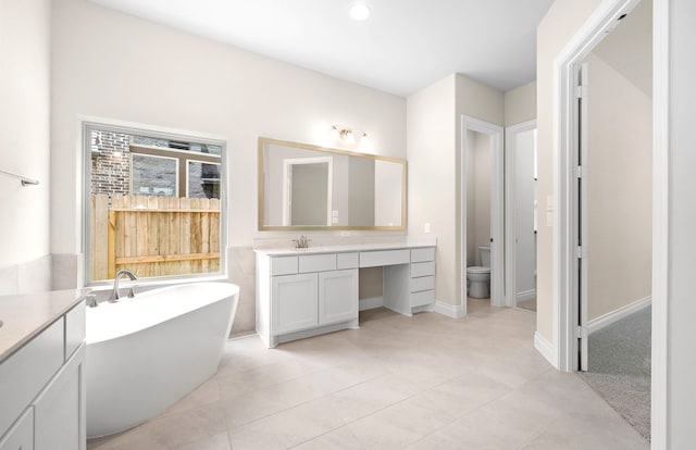 10719 Jacobina Ct, Cypress, TX 77433 - full bathroom with recessed lighting, tile patterned floors, a freestanding tub, toilet, and vanity