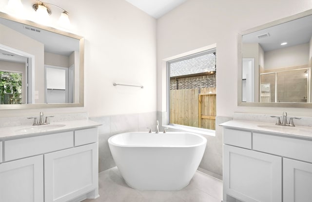 10719 Jacobina Ct, Cypress, TX 77433 - bathroom with a stall shower, tile walls, a sink, and two vanities
