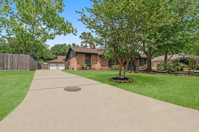 view of front of property with a chimney, a front yard, fence, brick siding, and a garage