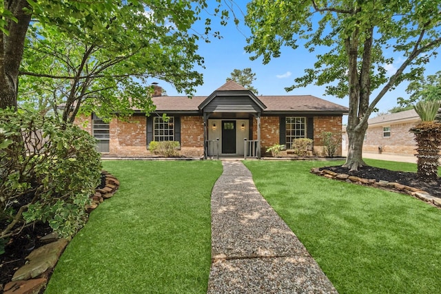 ranch-style house featuring a chimney, brick siding, and a front lawn