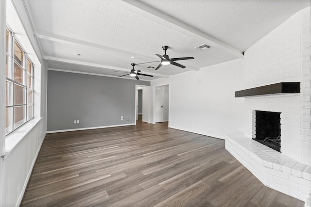 unfurnished living room with a fireplace, wood finished floors, ceiling fan, and visible vents
