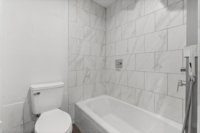 bathroom with toilet, shower / tub combination, and a textured wall