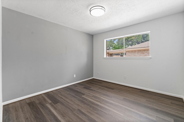 unfurnished room featuring a textured ceiling, wood finished floors, and baseboards