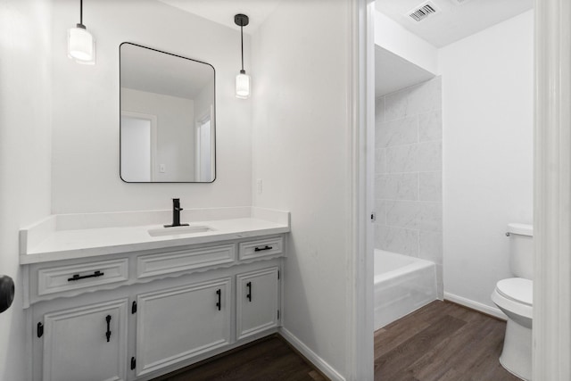 full bathroom with visible vents, baseboards, toilet, wood finished floors, and vanity