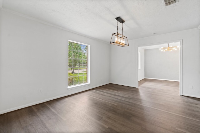 empty room featuring a chandelier, visible vents, ornamental molding, and wood finished floors