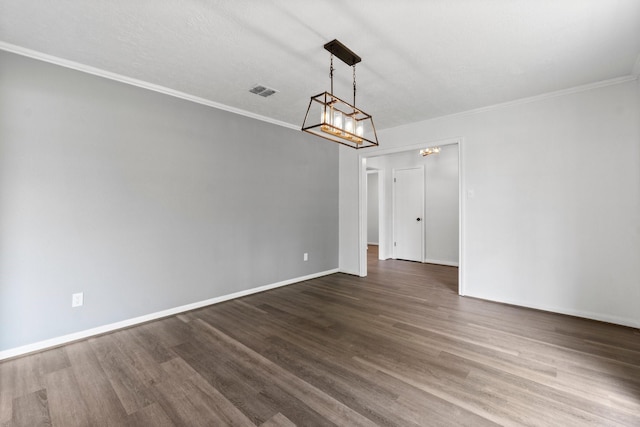 unfurnished dining area featuring visible vents, wood finished floors, ornamental molding, and baseboards