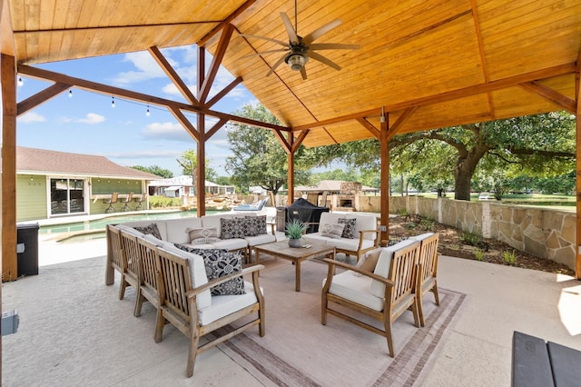 11008 Hillside Dr, Willis, TX 77318 - view of patio with fence, an outdoor living space with a fireplace, a gazebo, ceiling fan, and a fenced in pool
