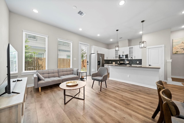 living room with visible vents, a wealth of natural light, light wood-style flooring, and recessed lighting