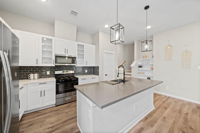 kitchen with tasteful backsplash, stainless steel appliances, light wood-type flooring, and a sink