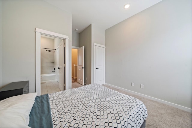 bedroom with baseboards, recessed lighting, ensuite bath, and light colored carpet