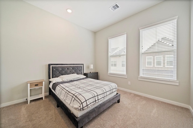 carpeted bedroom featuring baseboards and visible vents