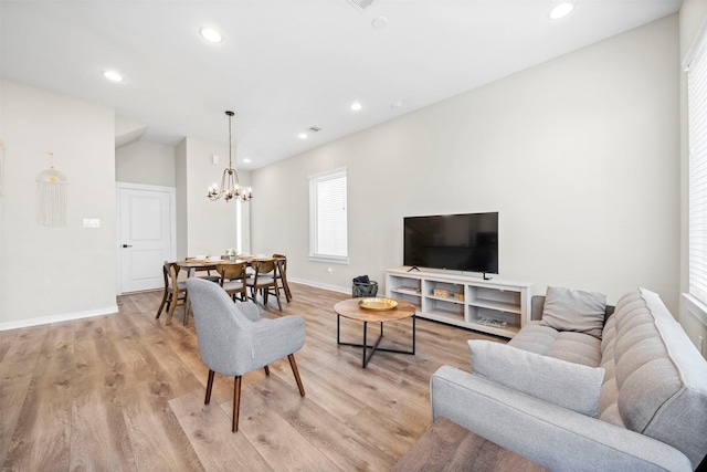 living room with recessed lighting, a notable chandelier, baseboards, and light wood-style floors