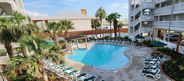 community pool with a fenced backyard and a patio area