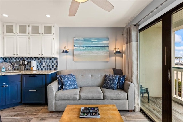 living room with recessed lighting, a ceiling fan, and light wood-style flooring