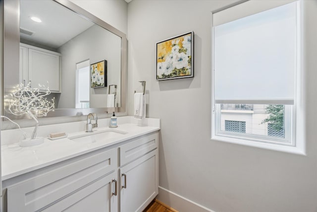 bathroom featuring visible vents, vanity, and baseboards