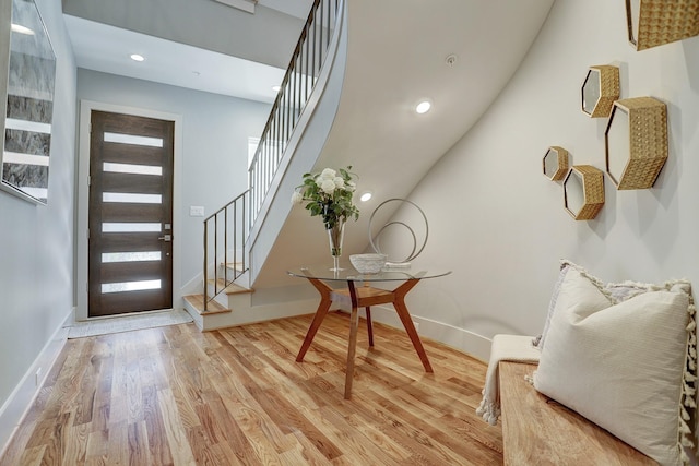 entryway with baseboards, stairway, and light wood-style floors