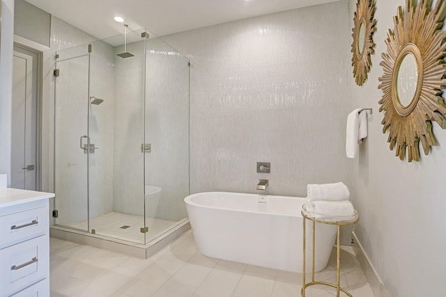 full bath with tile patterned floors, a stall shower, a freestanding bath, and vanity