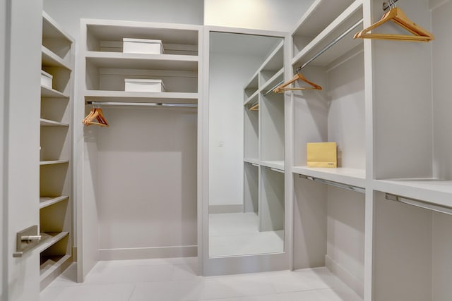 walk in closet with light tile patterned floors