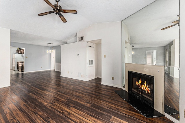 unfurnished living room featuring lofted ceiling, ceiling fan, visible vents, and a lit fireplace