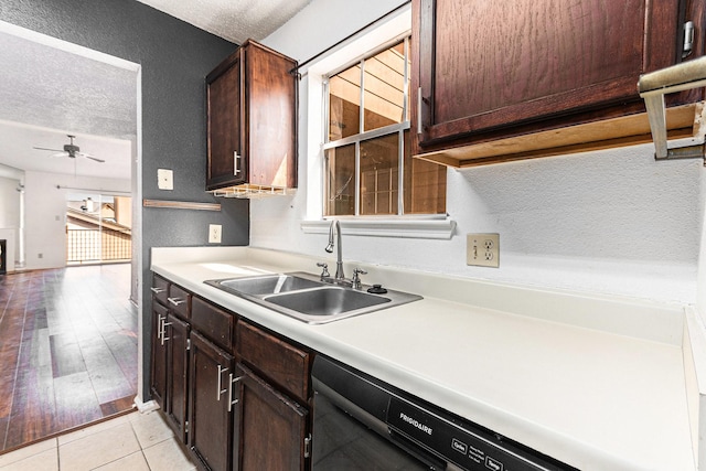 kitchen featuring a textured wall, dishwasher, a ceiling fan, and a sink