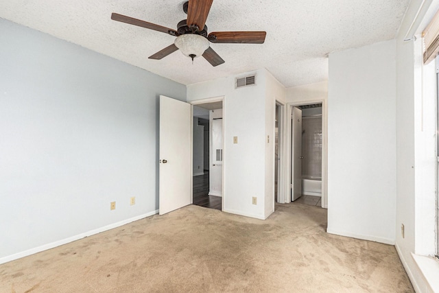 unfurnished bedroom with carpet, ceiling fan, baseboards, visible vents, and a textured ceiling
