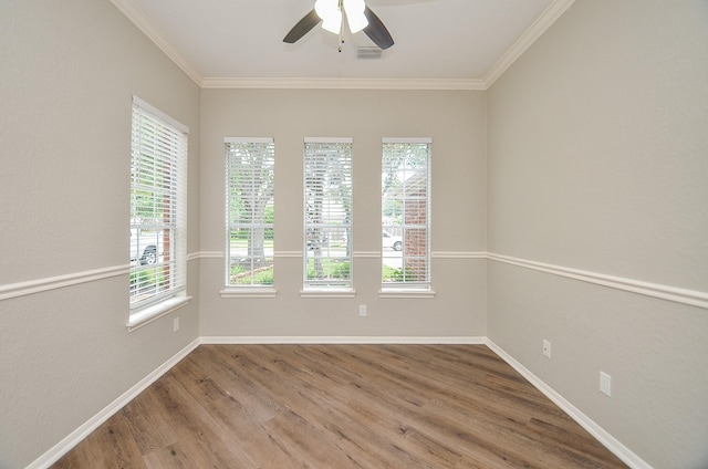 empty room featuring visible vents, wood finished floors, ceiling fan, and ornamental molding