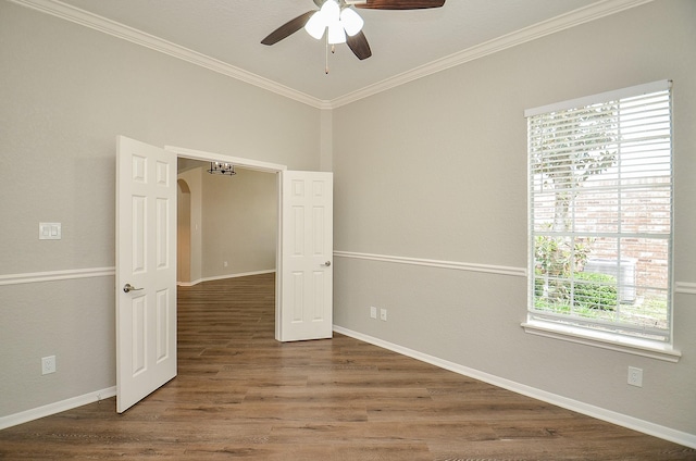 spare room with wood finished floors, a ceiling fan, and crown molding