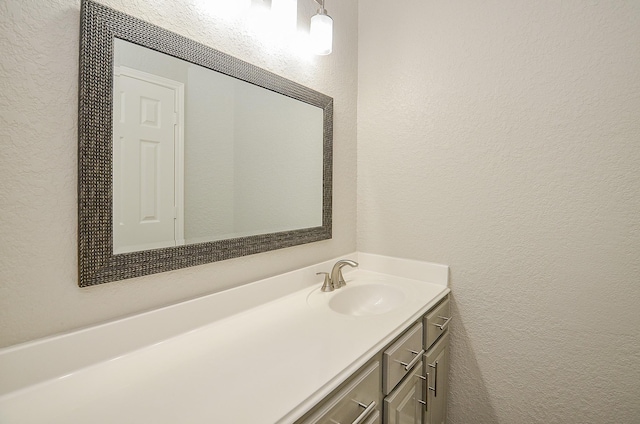 bathroom with a textured wall and vanity